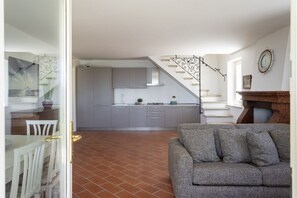 Eine moderne Küche mit grauen Schränken und einer Treppe zu einem Essbereich.