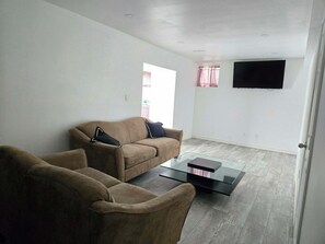 Una sala de estar con sofá, sillón y mesa de centro.