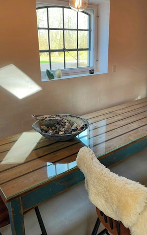 Ein Zimmer mit Fenster, einer Schale auf einem Tisch und einem flauschigen Gegenstand.