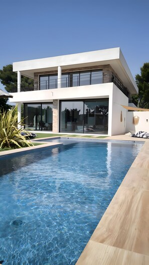Ein modernes, zweistöckiges Haus mit Schwimmbad.