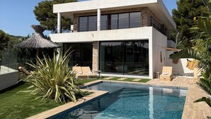 A modern two-story house with a swimming pool, outdoor seating, and a thatched umbrella. - Villa d'Exception sur la Presqu'île de Cassis - Heated pool & calanques view (Cassis)