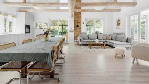 Ein geräumiges Zimmer mit Esstisch, Sofa und Blick ins Freie.