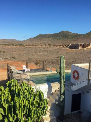 A desert landscape with a pool, cactus plants, and a lifebuoy. - Cortijo with eclectic décor near Almería (Albaricoques)