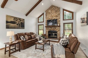 A living room with a stone fireplace, leather sofas, and artwork on the walls. - Horsey Heartland oasis 7 Mi WEC Close to all Fun (Ocala)