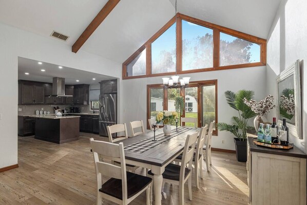 A spacious kitchen with dark cabinets, a central island, and a dining area with a large table and chairs. - Horsey Heartland oasis 7 Mi WEC Close to all Fun (Ocala)