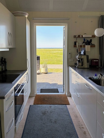 A modern kitchen with a view of a field, a coffee machine, and a toaster.. Fjord Views and a Child‑Friendly Beach in Lendrup