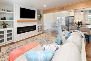 Ein Wohnzimmer mit Kamin, Fernseher und Sitzecke.
