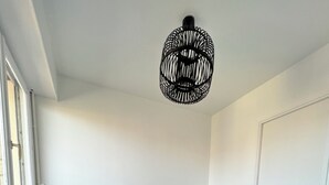 Quarto com uma cama, um radiador, uma janela e uma porta.