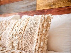A bed with a textured blanket and a wooden headboard. - Ocean View Studio in Essaouira (Essaouira)