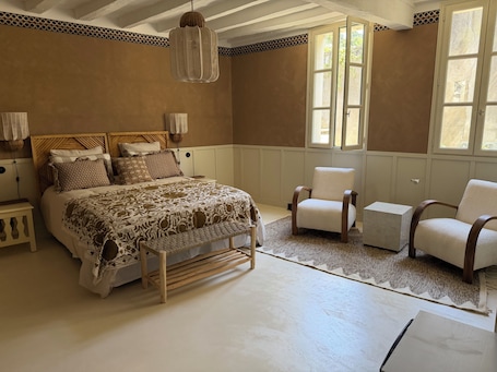 A bedroom with a bed, two chairs, a bedside table, a hanging light fixture, and a window.. Top-of-the-range "Amber Brown" B&B room in Chinon town center