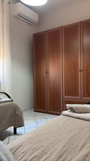 A bedroom with a bed, a wardrobe, and an air conditioning unit. - Sea Breeze House for 4 people, 5 minutes from the beach (Fiumenaro)