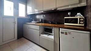 Eine Küche mit Mikrowelle, Backofen und Spüle.