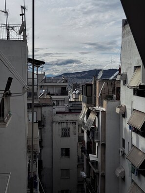A narrow urban street with closely packed buildings, some with balconies and satellite dishes. - Athens Stay 35 (Athina)