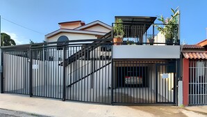 Um condomínio fechado com escadaria coberta, garagem e pequena varanda.