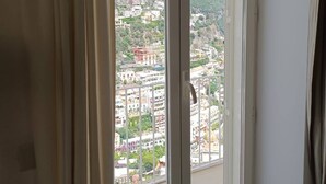 Ein Zimmer mit einer großen Schiebetür und einem Balkon mit Blick auf die Stadt.