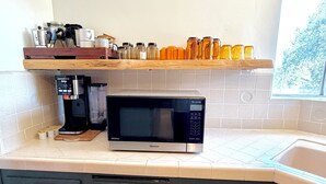 A kitchen with a microwave, coffee maker, and various containers on a shelf. - 3-bedroom house in peaceful Sierras on 4.5 acres along road to Bass Lake (Wishon)