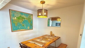 A dining area with a wooden table, bench, and a world map on the wall. - 3-bedroom house in peaceful Sierras on 4.5 acres along road to Bass Lake (Wishon)