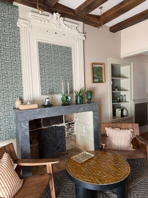 A cozy living room with a fireplace, wooden furniture, and a decorative mirror. - Upmarket "Ame Soeur" B&B room in the center of Chinon (Chinon)