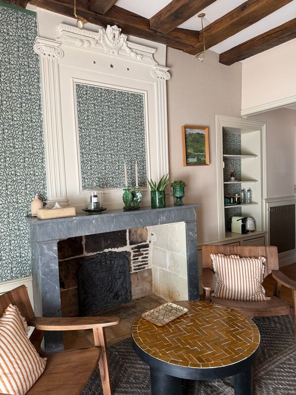 Una sala de estar acogedora con chimenea, muebles de madera y un espejo decorativo.
