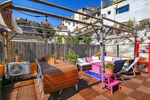 Una terraza de madera con un sofá, sillas y una mesa.