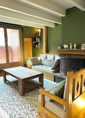 Ein gemütliches Wohnzimmer mit einer Holzsofa, einem Holztisch und einem gemusterten Teppich.