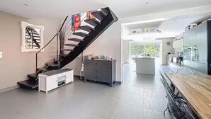 Een modern interieur met een wenteltrap, een keukenhoek en een eethoek.