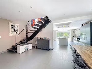 Ein modernes Interieur mit einer Wendeltreppe, einer Küchenzeile und einem Essbereich.