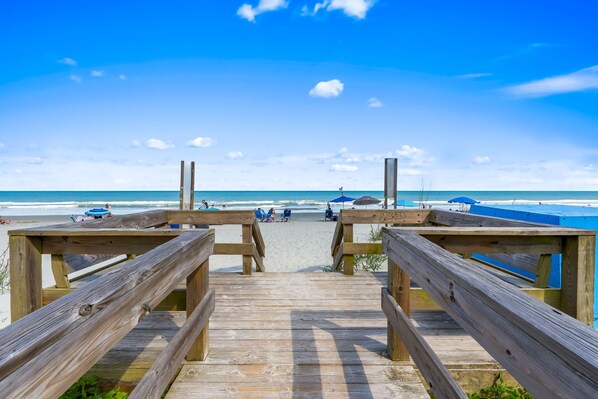 A wooden boardwalk leading to a beach with a clear sky. - Coastal Retreat Ocean and Pool Views 1st Floor (Murrells Inlet)