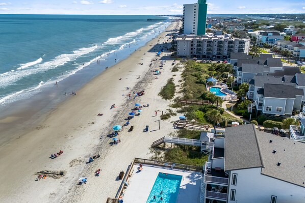 A beachside hotel with a swimming pool, beach access, and ocean views.