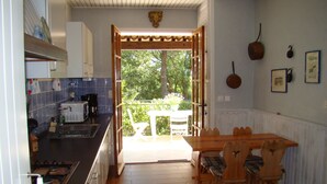 Una cocina con comedor, vistas al exterior y un techo con un detalle decorativo.