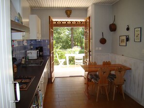 A kitchen with a dining area, a view to the outside, and a ceiling with a decorative element. - Villa Sainte Maxime, la Nartelle, 400 meters from the beach, sea view (Sainte-Maxime)