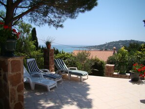 A terrace with two lounge chairs, a stone pillar, and a view of the sea and hills. - Villa Sainte Maxime, la Nartelle, 400 meters from the beach, sea view (Sainte-Maxime)