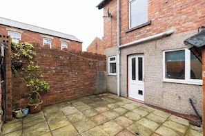 A brick house with a small garden area, a white door, and a window. - 3BR Home in Darlington | Contractor Rates (Darlington)