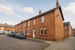 A two-story brick house with a garage, parked cars, and a cobblestone driveway. - Contractor-Friendly 3-Bed Home in Darlington (Darlington)