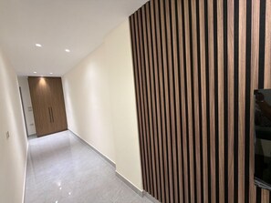 Ein Korridor mit Holzpaneelausstattung, einer Tür am Ende und einem Fliesenboden.