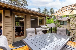 Un patio exterior con una parrilla, asientos y un área cubierta.