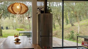 Een moderne keuken met een groot eiland, een eettafel met stoelen en uitzicht op het buitenleven.