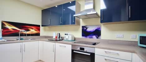 A modern kitchen with a built-in oven, a microwave, and a large window above the sink.