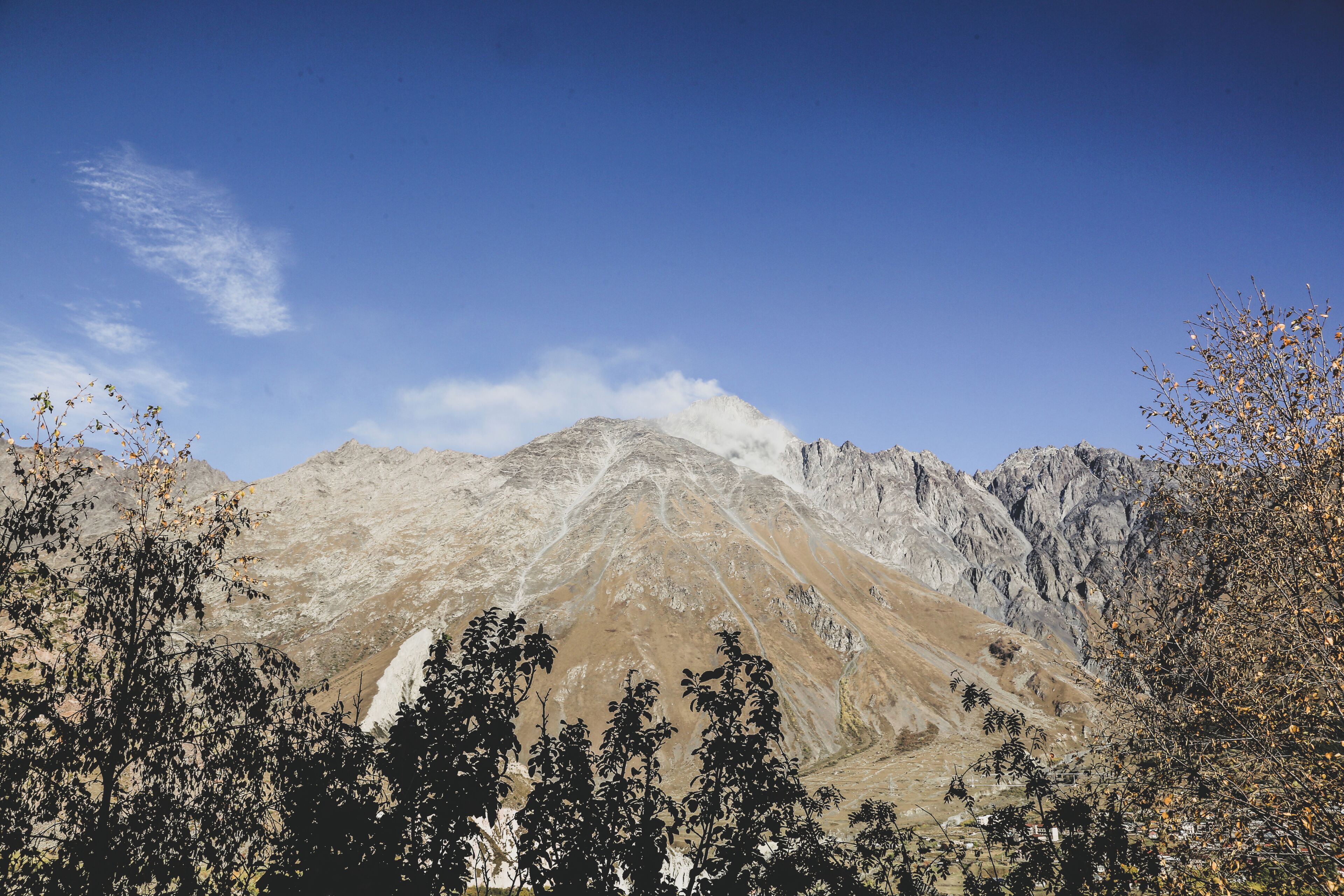 A mountain landscape with rocky terrain and sparse vegetation.