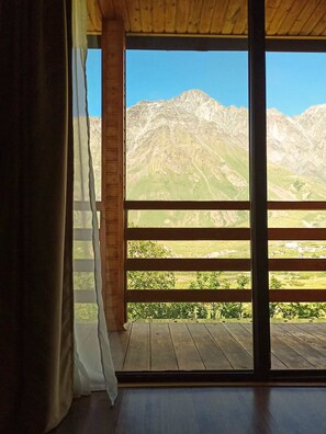 Una habitación con un amplio ventanal con vistas a un paisaje monta ñoso.