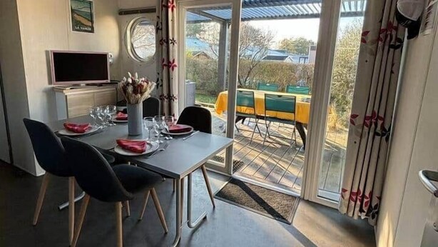 En matplats med ett bord för fyra personer, en tv och utsikt över omgivningarna.