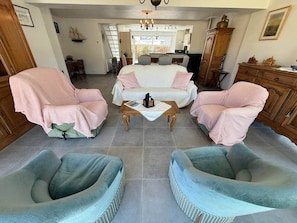 Ein Zimmer mit einem Bett, zwei Sesseln, einem Couchtisch und einem Essbereich.