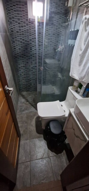 A small bathroom with a shower, toilet, and sink. - Nicholas Residence (Silang)