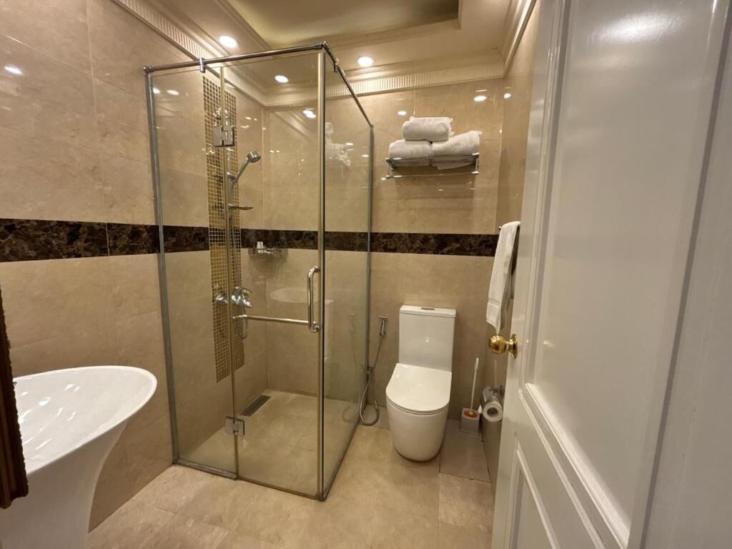 Une salle de bain avec une douche à parois de verre, des toilettes et un lavabo.