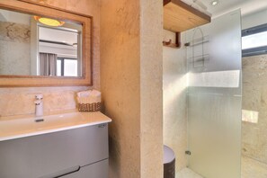 A bathroom with a marble sink, a mirror, and a glass shower enclosure. - Cozy 1-bedroom apartment jacuzzi Las Terrenas with AC (Las Terrenas)