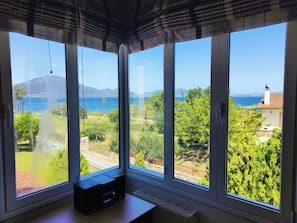 A room with large windows, a radiator, and a desk with a printer.