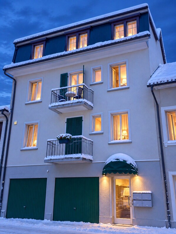 Un immeuble à plusieurs étages doté d’un balcon, de fenêtres et d’une porte.