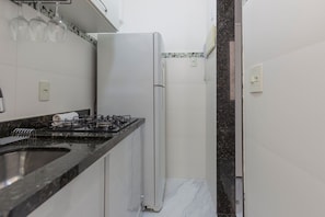 Una cucina con un piano cottura a gas, un frigorifero e un lavello.