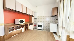 A compact kitchen with a microwave, stove, and small refrigerator. - SE267 – Senigallia, two-bedroom apartment 300 metres from the sea (Senigallia)