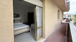 A room with a bed, a window with patterned curtains, and a balcony with a railing. - SE267 – Senigallia, two-bedroom apartment 300 metres from the sea (Senigallia)
